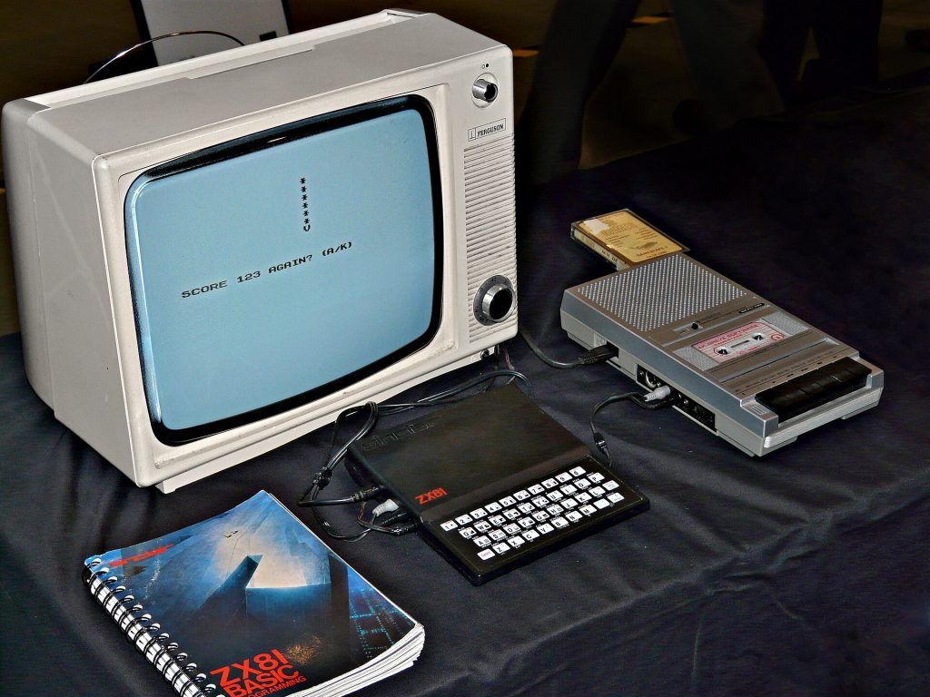 An image of the Sinclair ZX81, with a monochrome portable television, the computer's manual, and a cassette recorder