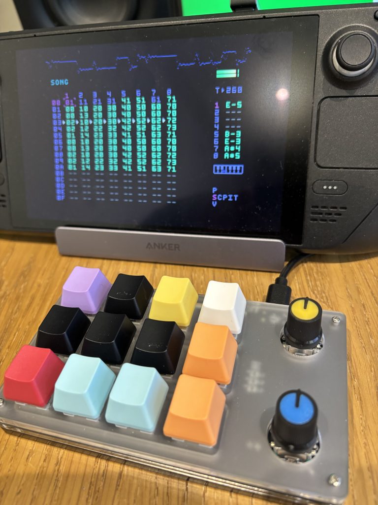 The image shows a SteamDeck, running DirtyWave M8 Software, and an external mini-keyboard with brightly coloured, legend-less buttons.